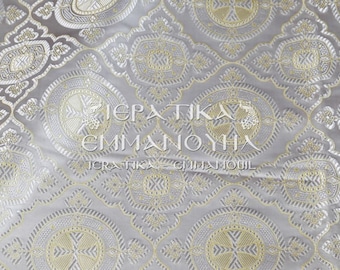 May include: A close-up of a silver fabric with a repeating pattern of gold circles and crosses. The fabric has the text "ΙΕΡΑΤΙΚΑ ΕΜΜΑΝΟΥΗΛ" printed on it.