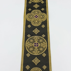 May include: Black ribbon with gold and purple embroidered geometric designs. The ribbon features repeating circular and diamond patterns with a cross motif. The text "EMMA 253 No.13" is visible on the ribbon.