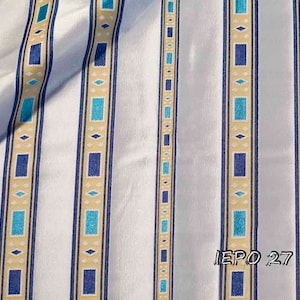 May include: White fabric with vertical stripes in blue, turquoise, and beige. The stripes have a geometric pattern. The fabric has a subtle sheen. The text "EPO 27 1111" is visible in the bottom right corner.
