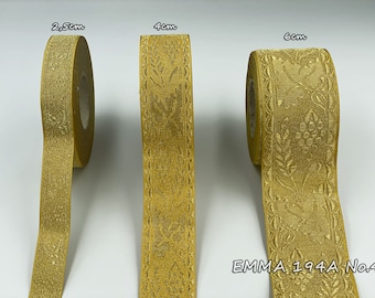 Op de afbeelding: Drie rollen gouden lint met een bloemenpatroon. Het lint is verkrijgbaar in drie breedtes: 2,5 cm, 4 cm en 6 cm. Het label luidt "EMMA 1944A No.4".