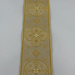 May include: A close-up of a decorative ribbon with a repeating pattern of gold crosses and floral designs on a beige background. The text "EMMA 253 No.5" is printed in the lower right corner.