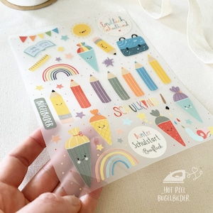 Può includere: Un foglio trasparente di trasferibili a caldo con illustrazioni colorate a tema scolastico. I disegni includono matite, arcobaleni, coni gelato, un sole e il testo "English Schulkind".