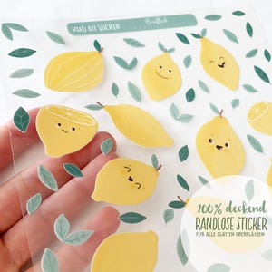Peut inclure: Feuille de stickers à frotter avec des citrons jaunes de dessin animé souriants et des feuilles vertes. Le texte "RUB ON STICKER" est en haut. Les autocollants sont étiquetés "100% deckend RANDLOSE STICKER" pour les surfaces lisses.