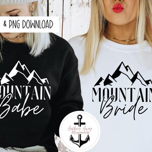 May include: Two black and white graphic designs featuring a mountain range with the text "Mountain Babe" and "Mountain Bride".