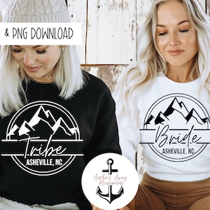 May include: Two white sweatshirts with black mountain and text designs. One says "Tribe Asheville, NC" and the other says "Bride Asheville, NC".