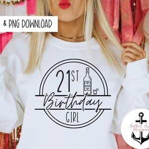 May include: White sweatshirt with a black circle design that says "21st Birthday Girl" with a bottle and glass inside the circle.