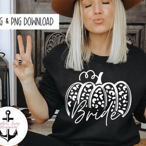 May include: A black sweatshirt with a white graphic of a pumpkin with a leopard print design and the word "bride" written underneath.