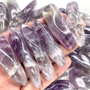 May include: A collection of amethyst tumbled stones, each with a unique shape and purple hue. The stones are smooth and polished, with a natural, organic look.