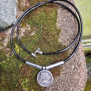 Op de afbeelding: Een zilveren Viking-schip hangerketting met een zwart leren koord. De hanger heeft een gedetailleerd ontwerp van een Viking-schip met zeilen.