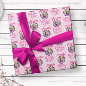 May include: Pink wrapping paper with a repeating pattern of white circles containing a photo of a child and the text "Happy Birthday to You".