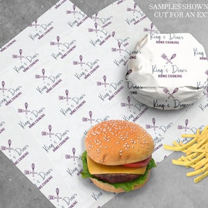 Peut inclure: Papier blanc avec un motif r&eacute;p&eacute;t&eacute; d'un logo violet qui dit "King's Diner Home Cooking" avec un design de cuill&egrave;re et de spatule violet. Un hamburger envelopp&eacute; dans le papier avec un fond blanc et le m&ecirc;me logo. Le hamburger a un pain aux graines de s&eacute;same, de la laitue, de la tomate et du fromage. Un tas de frites sur une surface grise.