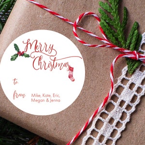 May include: White round gift tag with red and green holly, a red and white striped stocking, and the text "Merry Christmas" in red cursive. The tag also says "to" and "from" with the names "Mike, Kate, Eric, Megan & Jenna" written below.