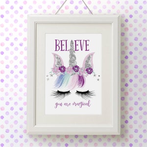 May include: A white framed print with a unicorn illustration. The unicorn has a silver horn, purple flowers, and pink ears. The text "BELIEVE you are magical" is printed below the unicorn.