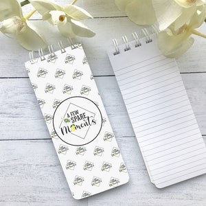 May include: A white spiral bound notepad with a lemon and leaf design and the text "A Few Spare Moments". The notepad has lined pages.