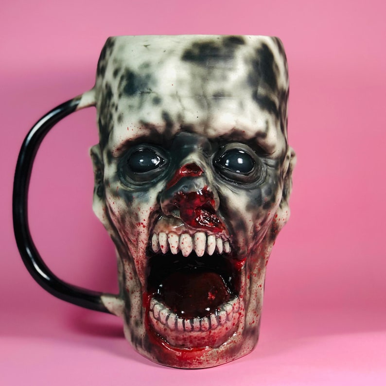 Handcrafted 43.95 oz vampire zombie mug featuring hyper-realistic anatomical details and blood-splattered accents. Limited edition with only 50 pieces, each uniquely numbered. Sculpted and hand-painted using Amacobrent ceramic glaze for an eerie and gothic aesthetic. Made from high-quality, lead-free ceramic for safe daily use. Microwave and dishwasher safe. A must-have collectible for horror lovers, gothic decor enthusiasts, and Halloween collectors.