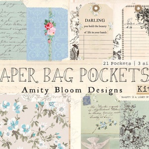 Op de afbeelding: Een set van 21 papieren zakjes in drie maten, met een bloemenpatroon met blauwe en witte bloemen. De tekst "PAPER BAG POCKETS" en "Amity Bloom Designs" is in zwart gedrukt. De tekst "Kit 1" is in zwart op een witte achtergrond gedrukt. De tekst "DARLING you hold the beauty of life in your hands" is gedrukt op een beige label.