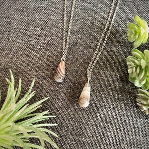Peut inclure: Deux colliers en argent avec des pendentifs en forme de larme en agate. L'agate est de couleur brun clair et blanc avec un motif tourbillonnant.