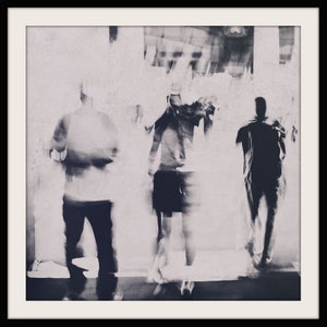 Peut inclure: Une photo en noir et blanc de trois personnes marchant dans un arrière-plan flou. Les personnes sont floues et semblent se déplacer rapidement.