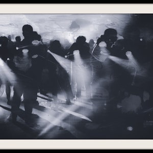 Könnte beinhalten: Ein Schwarzweißfoto einer Gruppe von Menschen, die in einem dunklen Raum mit Scheinwerfern stehen, die auf sie gerichtet sind.