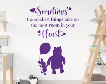 Puede incluir: Pegatina de pared en silueta de Winnie de Pooh y Piglet de color morado con la cita "A veces las cosas más pequeñas ocupan el mayor espacio en tu corazón."