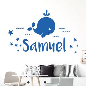 May include: Blue whale wall decal with the name Samuel and stars. The whale is swimming in waves.