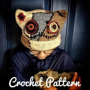 May include: A handmade crochet hat with a patchwork design, featuring tan, brown, and gray sections. The hat has large button embellishments and stitched details, with the text "Crochet Pattern" at the bottom.