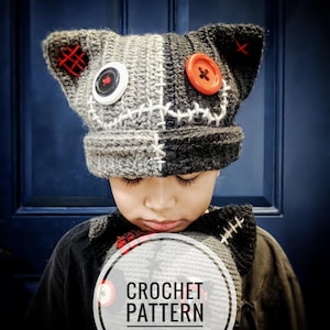 May include: A handmade crochet hat with a unique design. The hat is split into gray and black sections, with white stitching and red accents. It features a large white button and an orange button. The image also includes the text "CROCHET PATTERN".