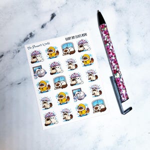 May include: A sheet of stickers featuring illustrations of cats in raincoats and under umbrellas. The stickers have the text "The Planner's World" and "Rainy Day Floofs MS041". A pen with a floral design is also in the image.