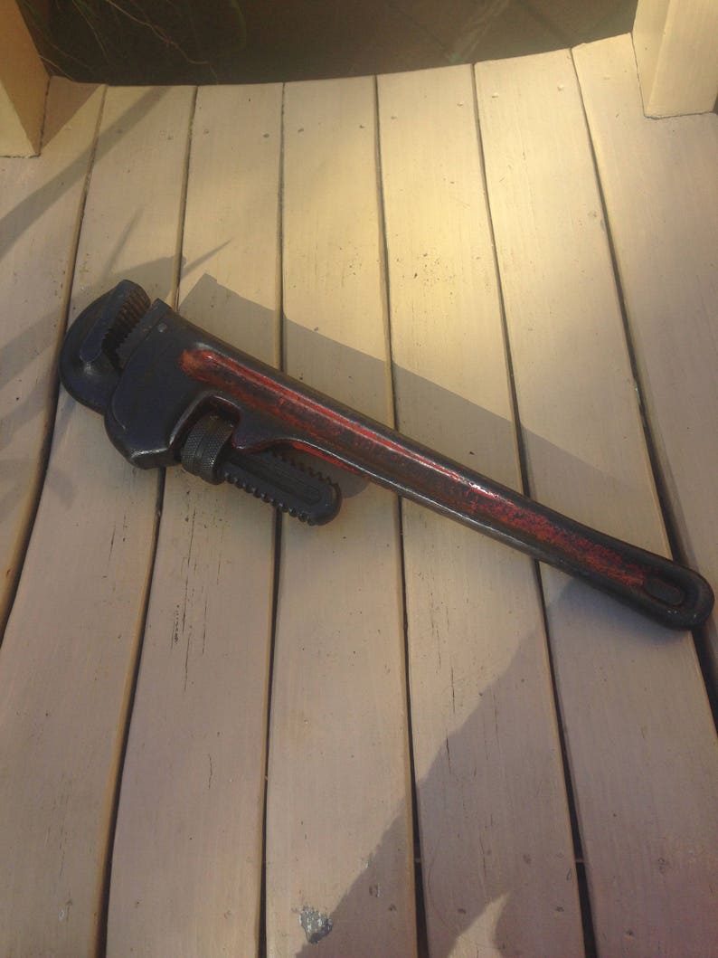 May include: A black and red pipe wrench with a black handle and a red painted body.