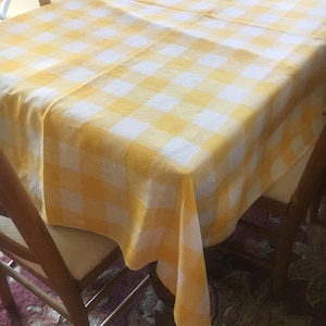 May include: A white ceramic mug with a black handle and the text "But First, Coffee" in a bold, black font. The mug is sitting on a wooden surface. The mug is approximately 4 inches tall.