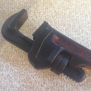 May include: A black pipe wrench with a red handle and the text "THE RIDGE TOOL CO."