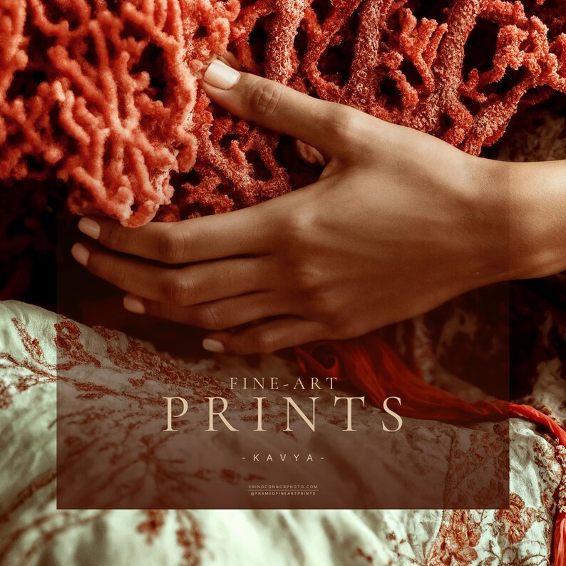 Close detail of Kavya fine art print showing hand holding red coral over ivory patterned fabric