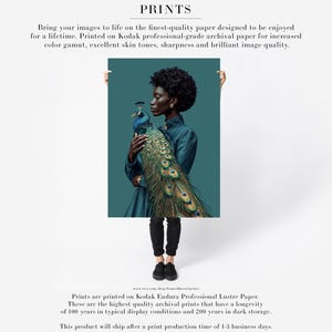 Puede incluir: Una impresi&oacute;n de una persona sosteniendo un pavo real. La persona lleva un vestido verde azulado y pantalones negros. Las plumas del pavo real muestran tonos de verde, azul y dorado. La impresi&oacute;n est&aacute; etiquetada como "PRINTS".
