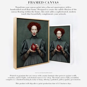 Framed portrait of Cinder printed on canvas and displayed in a modern natural wood float frame, featuring a red-haired woman holding a sculpted heart vessel on a moody green background.