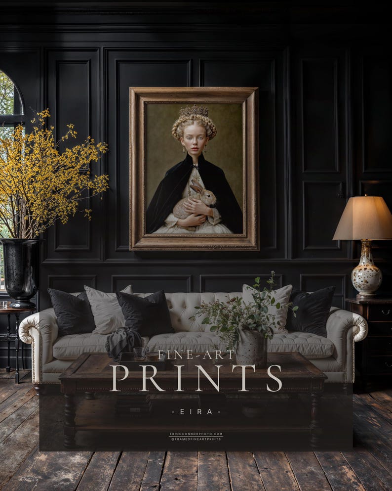 Eira framed fine art print displayed in antique gold frame on black paneled wall above cream tufted sofa in a dark academia living room