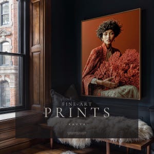 Kavya framed fine art print displayed on deep blue wall above window seat in moody interior