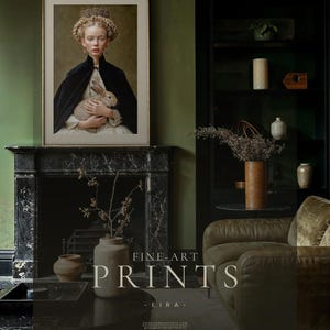 Eira framed fine art print displayed above black marble fireplace in a moody green living room with bookshelves and dark academia styling