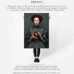 Fine art paper print of Cinder, featuring a woman in dark vintage clothing holding a vivid red heart, printed with archival inks and designed for timeless wall presentation.