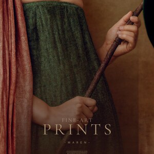 Detail of Maren's pregnant form and hands holding a magnolia branch against her textured botanical green dress and dusty rose drape.