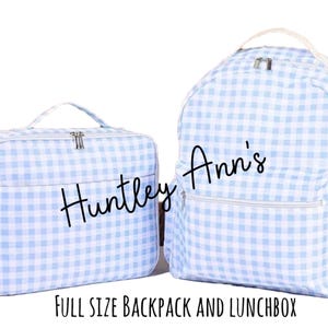 Puede incluir: Un juego a juego de una mochila y una lonchera de tama&ntilde;o completo. Ambos art&iacute;culos presentan un patr&oacute;n de cuadros de vichy azul claro y blanco. La mochila tiene un asa superior y bolsillos laterales. La lonchera tiene un asa superior y cierre de cremallera. El texto "Huntley Ann's" est&aacute; escrito en ambos art&iacute;culos.