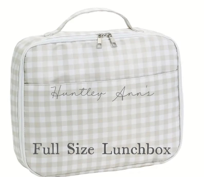 May include: A full-size lunchbox with a light gray and white gingham pattern. The lunchbox has a handle, a zippered closure, and a front pocket. The text "Huntley Ann's" and "Full Size Lunchbox" are printed on the front.