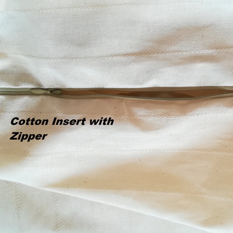 May include: Close-up of a white cotton fabric with a zipper. The fabric has a subtle striped pattern and the text "Cotton Insert with Zipper" is visible.