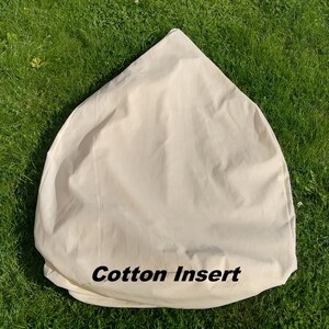 May include: A white cotton insert for a bean bag chair. The insert is shaped like a cone and has the words "Cotton Insert" printed on the bottom.