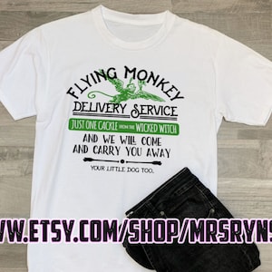 May include: White t-shirt with a green graphic of a flying monkey and the text "Flying Monkey Delivery Service. Just one cackle from the Wicked Witch and we will come and carry you away. Your little dog too."