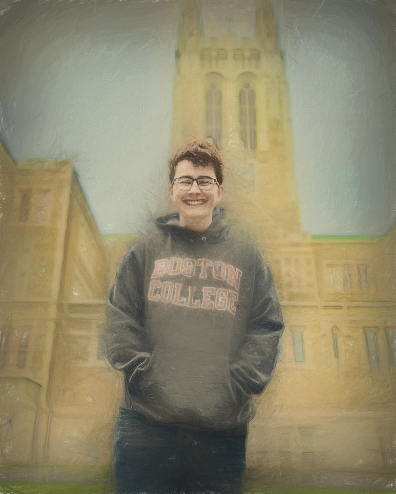 Pu&ograve; includere: Una persona con una felpa grigia del Boston College e occhiali sorride davanti a un grande edificio giallo. La felpa ha le parole "BOSTON COLLEGE" in un font rosso e bianco. Lo sfondo &egrave; un cielo nuvoloso.