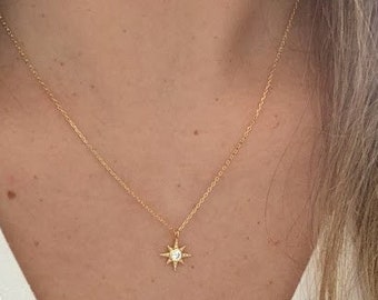 Peut inclure: Un collier délicat en chaîne dorée avec un petit pendentif en forme d'étoile orné d'une seule pierre transparente au centre.