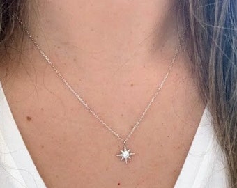 Peut inclure: Un collier en argent avec un petit pendentif en forme d'étoile scintillante.