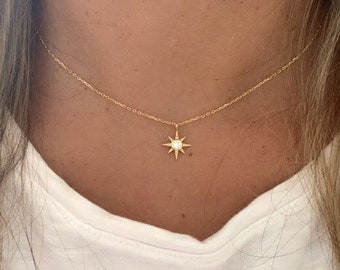 Peut inclure: Un collier en chaîne dorée avec un petit pendentif en forme d'étoile orné d'une pierre transparente au centre.