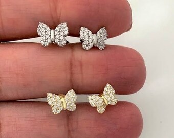 May include: Two pairs of butterfly earrings. One pair is silver with clear stones and the other pair is gold with clear stones.