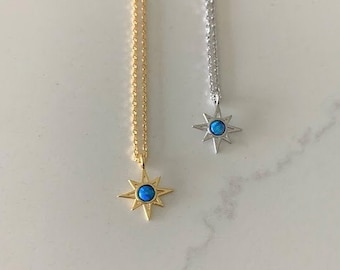 Peut inclure: Deux colliers délicats avec un pendentif en forme d'étoile orné d'une pierre d'opale bleue. L'un est en or et l'autre en argent.